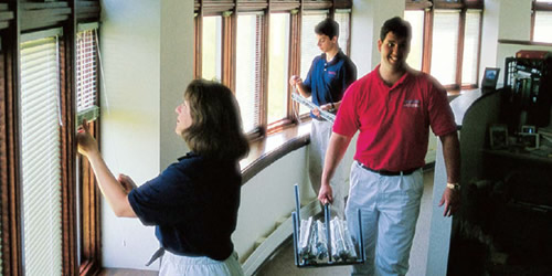 three people cleaning blinds