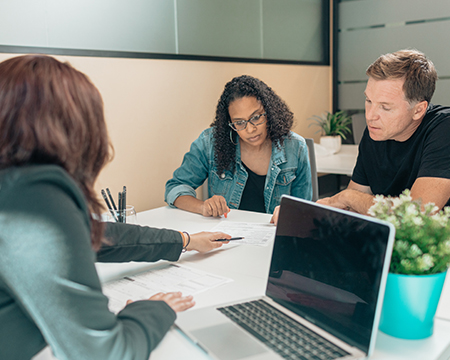 three people reviewing financial documents