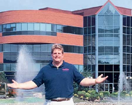 owner standing in front of a brick building